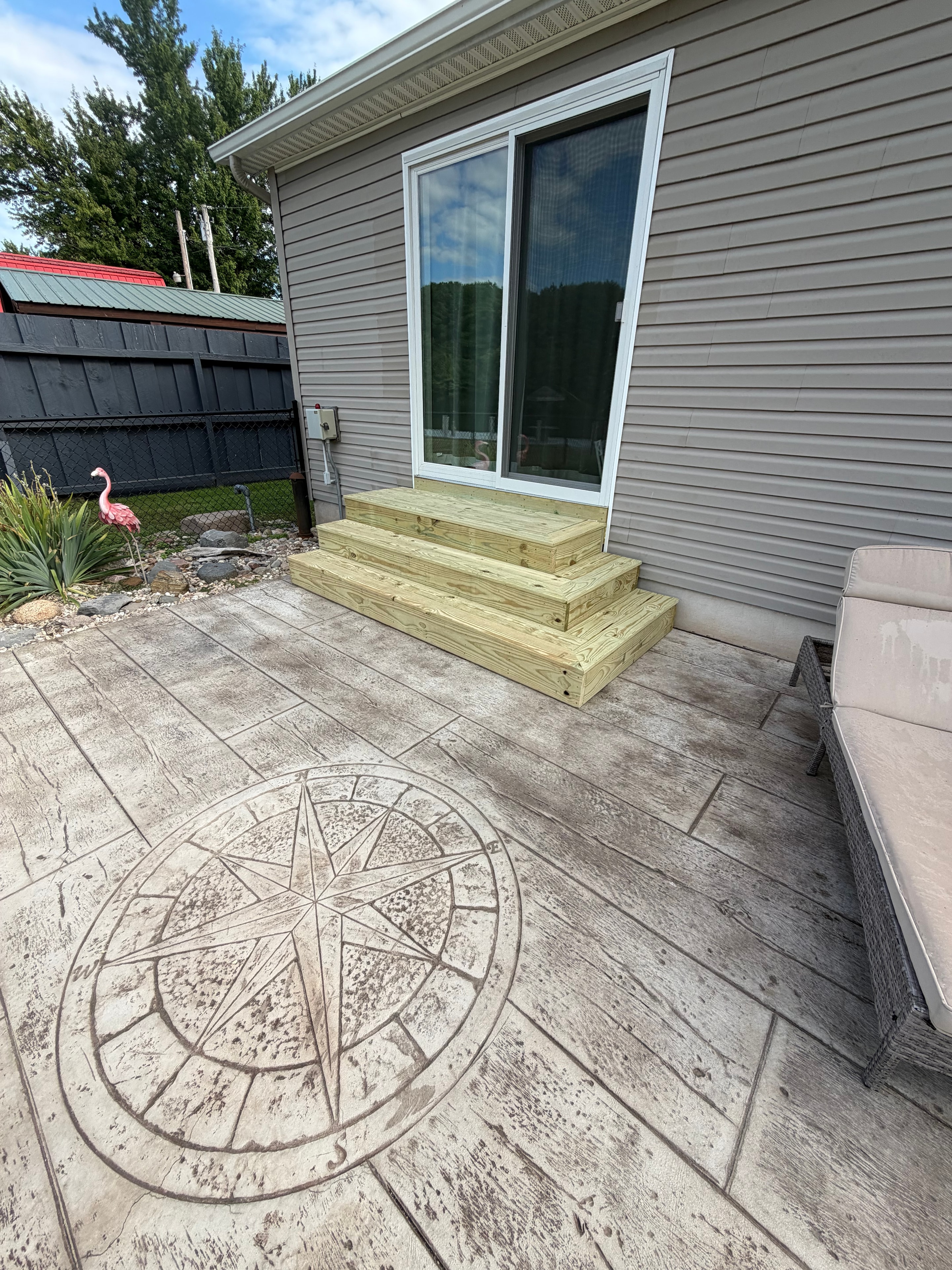 Stamped concrete patio with compass rose and new steps