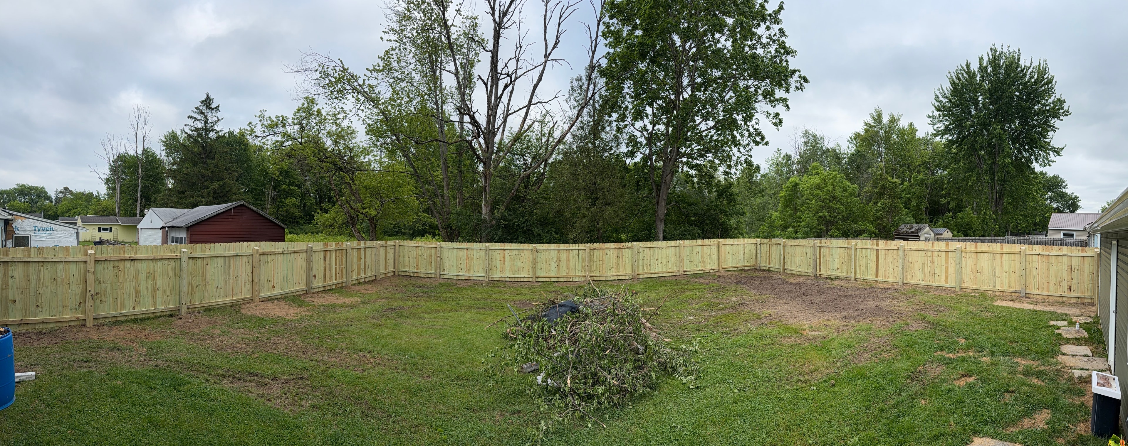 Panoramic new wood fence enclosing full backyard