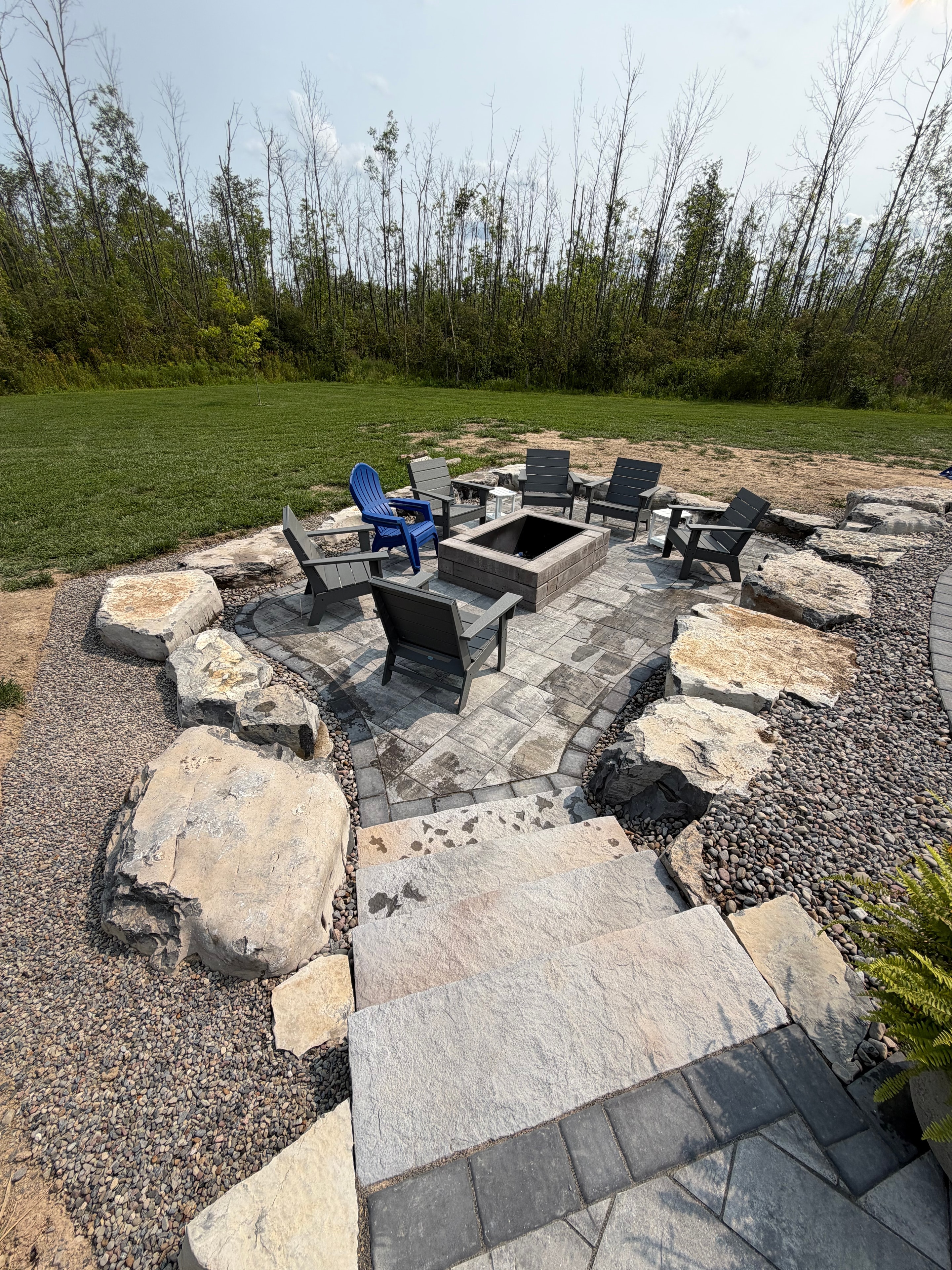 Fire pit seating area with stone pavers and boulders
